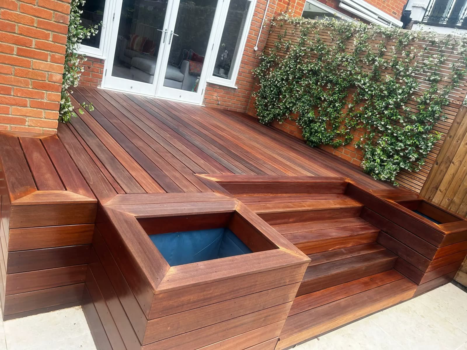 Hardwood garden decking with planters and jasmine wall