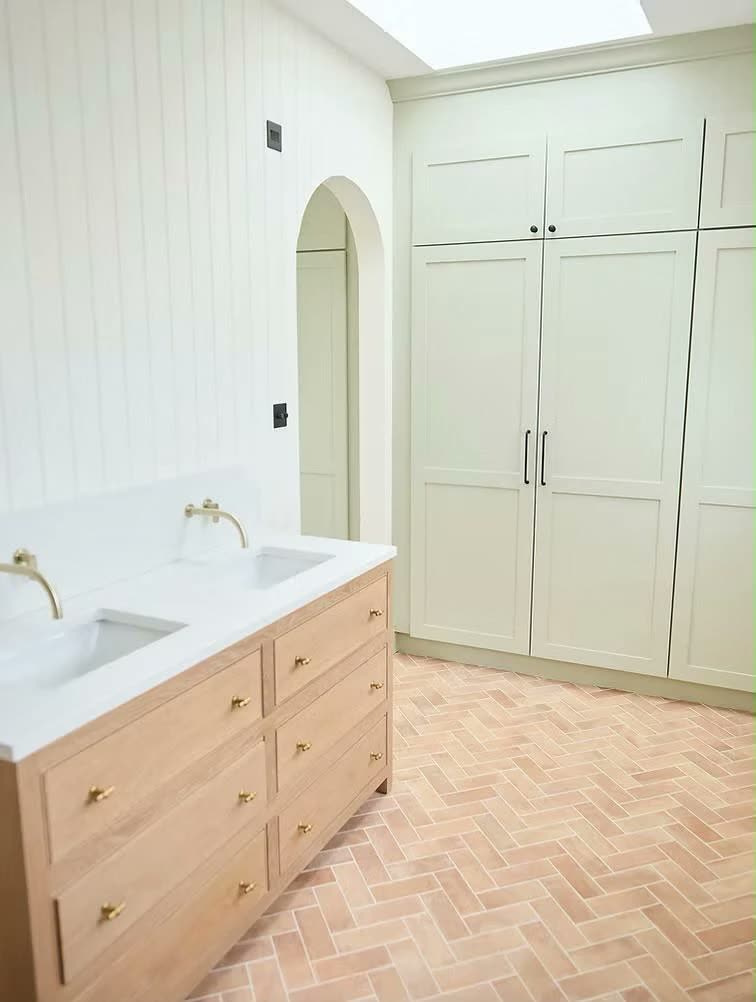 Oak double vanity with brass taps and sage cupboards